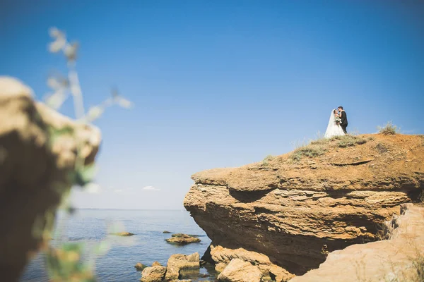 Feliz y romántica escena de recién casada joven pareja de boda posando en la hermosa playa — Foto de Stock