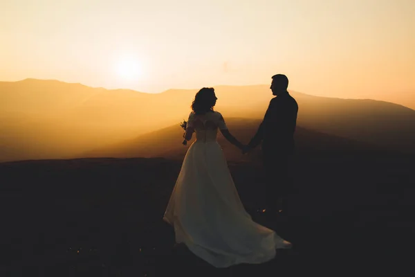 Szczęśliwy piękny ślub para panna młoda i pan młody w dniu ślubu na świeżym powietrzu w górach skała. Szczęśliwy ślub para na zewnątrz na łonie natury, miękkie słoneczne światła — Zdjęcie stockowe