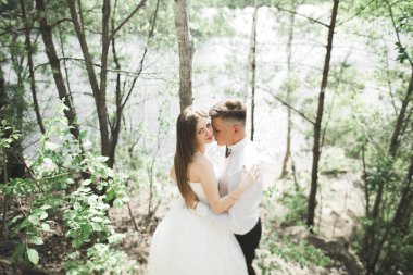 Öpüşen düğün çifti güzel manzarada kalıyor.