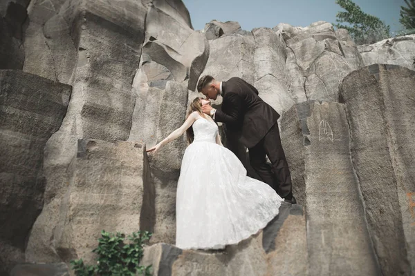 Splendida sposa, sposo baciare e abbracciare vicino alle scogliere con vista mozzafiato — Foto Stock