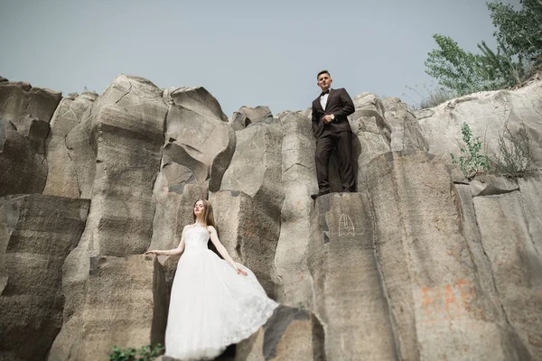 Schönes Hochzeitspaar in den Bergen mit Felsen — Stockfoto