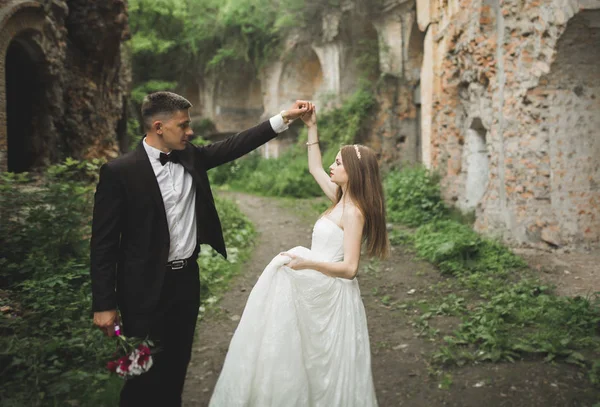 Krásný romantický svatební pár novomanželé objímání v blízkosti starého hradu — Stock fotografie