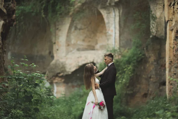 Just married poses and kissing with an old fortress on the background — Stock Photo, Image