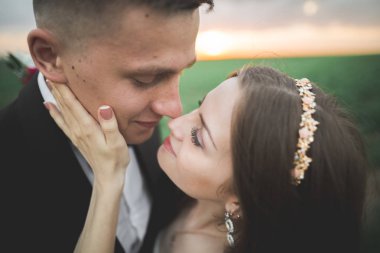 Düğün, güzel romantik gelin ve damat öpüşme günbatımında kucaklayan