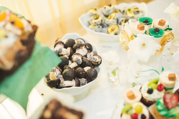 Delicious and tasty dessert table with cupcakes shots at reception closeup — Stock Photo, Image