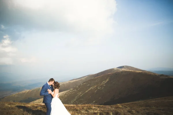 Linda noiva linda posando para noivo e se divertindo, cerimônia de luxo em montanhas com vista incrível, espaço para texto, casal de casamento — Fotografia de Stock