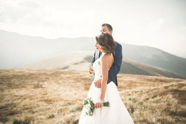 Magnifique couple de mariage embrasser et embrasser près de la montagne avec une vue parfaite — Photo