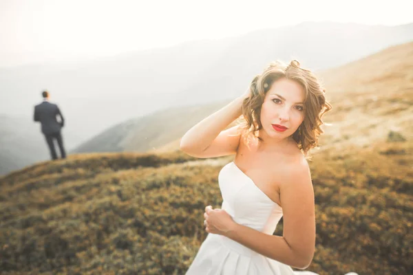 Feliz casamento bonito casal noiva e noivo no dia do casamento ao ar livre na rocha montanhas. Casamento feliz casal ao ar livre na natureza, luzes ensolaradas macias — Fotografia de Stock