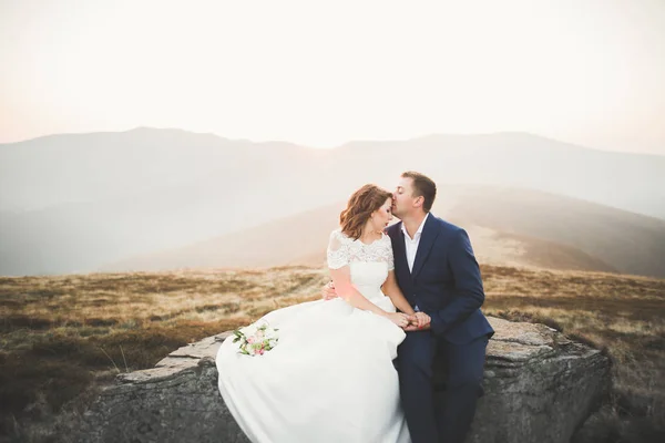 美丽的新婚夫妇在日落时构成一座山上 — 图库照片