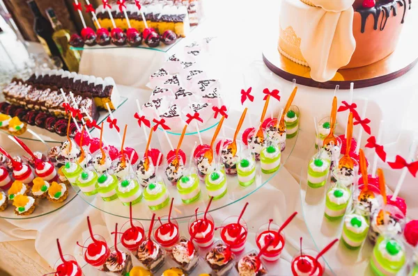 Deliciosos dulces en el buffet de dulces de boda con postres, cupcakes — Foto de Stock