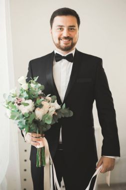 Güzel adam, damat poz veriyor ve düğüne hazırlanıyor.