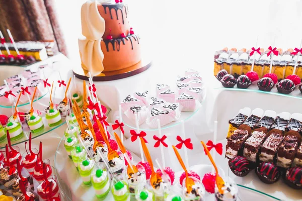 Delicious and tasty dessert table with cupcakes shots at reception closeup — Stock Photo, Image