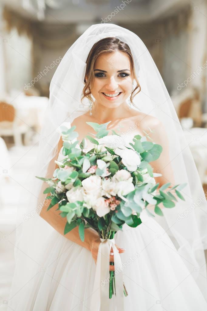 Wonderful bride with a luxurious white dress and bouquet