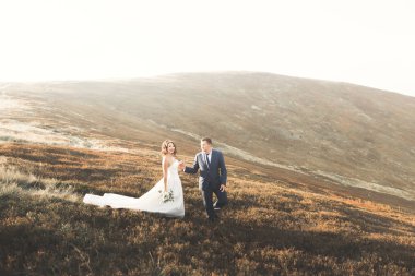 Harika bir gelin damada poz veriyor ve harika manzaralı dağlarda lüks bir tören yapıyor.