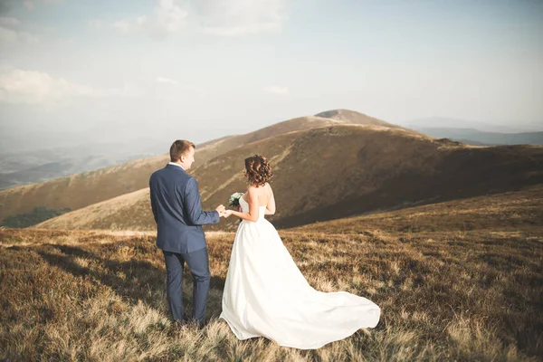 Prachtige prachtige bruid poseren om bruidegom en het hebben van plezier, luxe ceremonie in de bergen met een prachtig uitzicht, ruimte voor tekst, bruiloft paar — Stockfoto