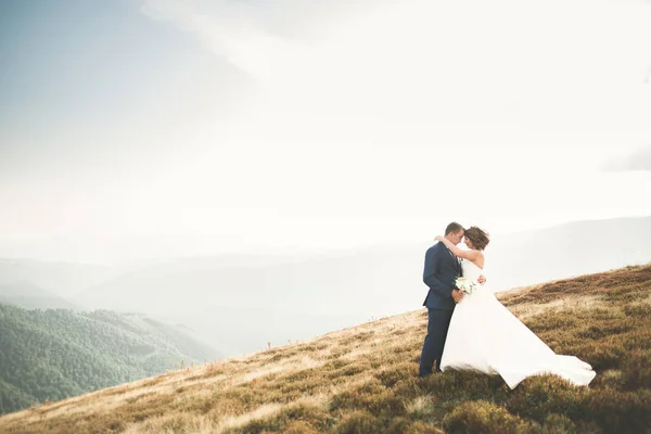 Casal feliz posando sobre bela paisagem nas montanhas — Fotografia de Stock