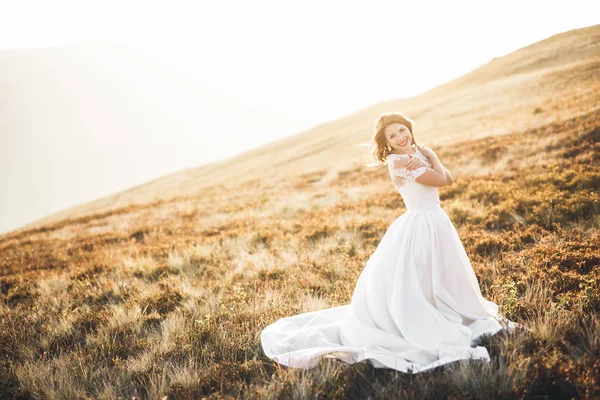 Felice bella giovane sposa fuori su un prato estivo al tramonto — Foto Stock