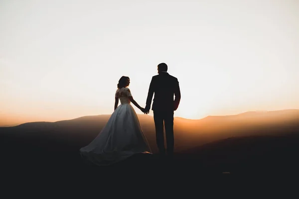 Ευτυχισμένο όμορφο γαμήλιο ζευγάρι νύφη και γαμπρός την ημέρα του γάμου σε εξωτερικούς χώρους στο βράχο βουνά. Ευτυχισμένο ζευγάρι γάμος σε εξωτερικούς χώρους για τη φύση, μαλακό ηλιόλουστα φώτα — Φωτογραφία Αρχείου