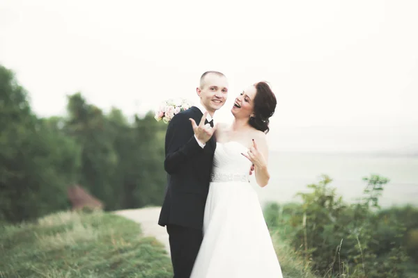 Hermosa pareja de recién casados cuento de hadas abrazándose cerca del antiguo castillo medieval — Foto de Stock