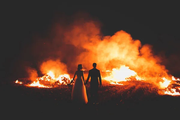 Increíble pareja de boda cerca del fuego por la noche — Foto de Stock