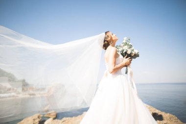 Arka planda beyaz elbiseli romantik gelin pozu