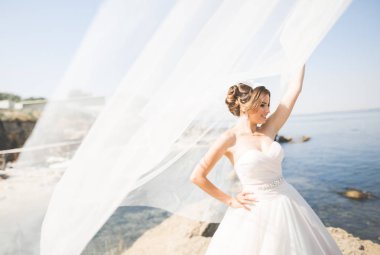 Arka planda beyaz elbiseli romantik gelin pozu