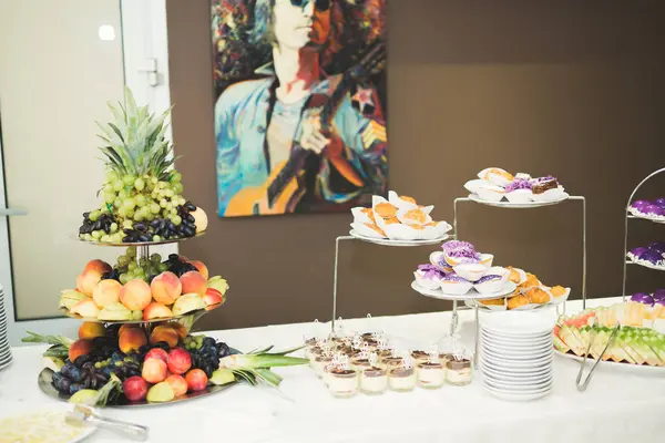 Délicieuse et savoureuse table à dessert avec des petits gâteaux plans à la réception gros plan — Photo