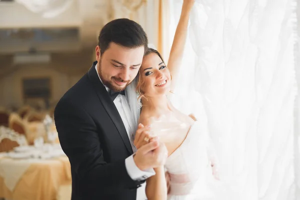 Gorgeous groom gently hugging stylish bride. Sensual moment of luxury wedding couple — Stock Photo, Image