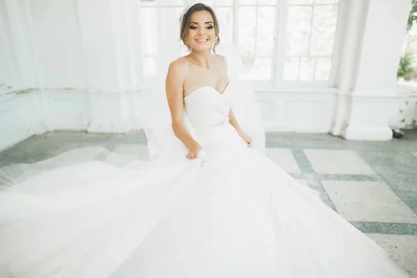 Bella sposa in abito da sposa con gonna lunga completa, sfondo bianco, danza e sorriso — Foto Stock