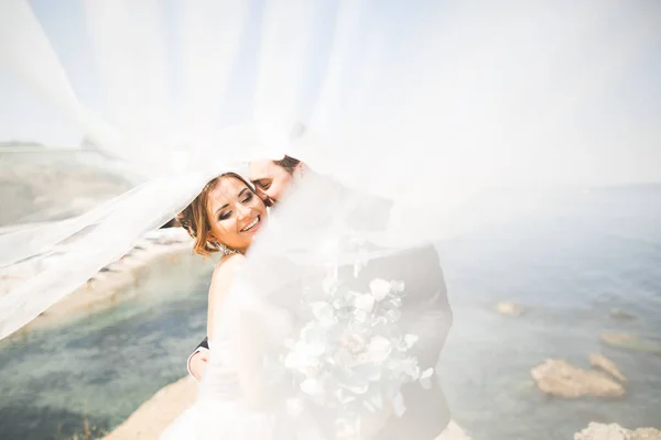 Gelukkig en romantisch tafereel van net getrouwd jong bruidspaar poserend op mooi strand — Stockfoto