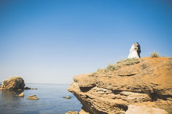 Scène heureuse et romantique de jeune couple marié posant sur une belle plage — Photo