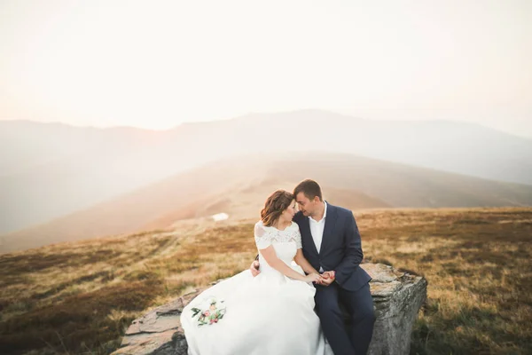 Beautifull wedding couple kissing and embracing near mountain with perfect view — Stock Photo, Image