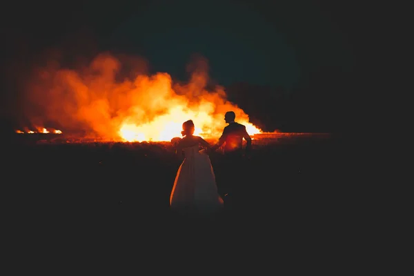 Increíble pareja de boda cerca del fuego por la noche — Foto de Stock