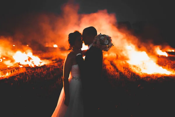 Increíble pareja de boda cerca del fuego por la noche — Foto de Stock