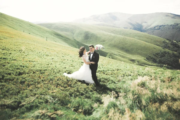 Prachtige prachtige bruid poseren om bruidegom en het hebben van plezier, luxe ceremonie in de bergen met een prachtig uitzicht, ruimte voor tekst, bruiloft paar — Stockfoto