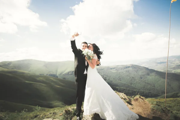 Schönes junges Hochzeitspaar macht Selfie vor dem Hintergrund der Berge — Stockfoto