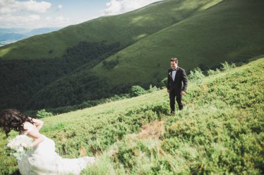 Harika bir gelin damada poz veriyor ve harika manzaralı dağlarda lüks bir tören yapıyor.