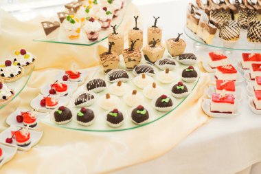 Çeşitli lezzetli tatlılar, yemek fikirleri ve kutlamalarla dolu bir büfe.