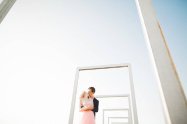 Çatıda mükemmel şehir manzaralı elele ve sarılma poz aşık genç bir çift. Güzel gün batımı