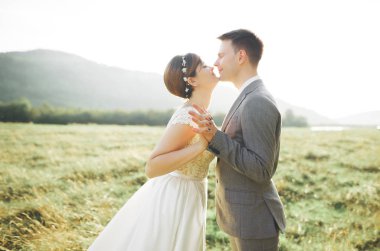 Öpüşen düğün çifti güzel manzarada kalıyor.