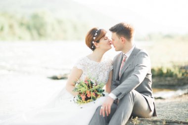 Yakışıklı romantik damat ve güzel gelin Nehri manzaralı dağlarında yakınında poz