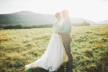 Yeni evli çift el ele tutuşurken parkta koşup zıplıyorlar.