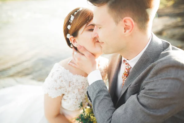 Feche o retrato do par contra o rio e árvores verdes. Mulher bonita beijando homem bonito ao ar livre — Fotografia de Stock