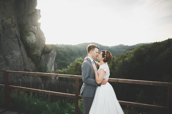 Líbání svatební pár pobyt nad krásnou krajinou — Stock fotografie