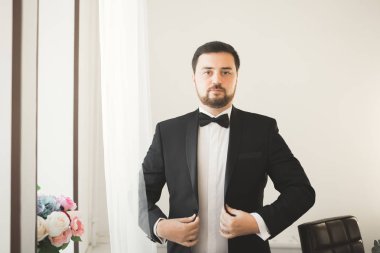 Güzel adam, damat poz veriyor ve düğüne hazırlanıyor.
