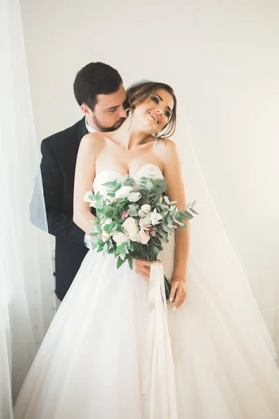 Sessão de fotos de casamento do casal recém-casados em um belo hotel posando perto da janela — Fotografia de Stock