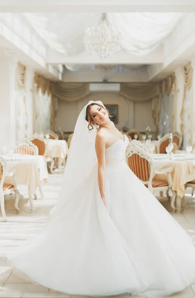 Bela noiva vestindo vestido de noiva de moda com penas com deleite de luxo maquiagem e penteado, estúdio sessão de fotos indoor — Fotografia de Stock