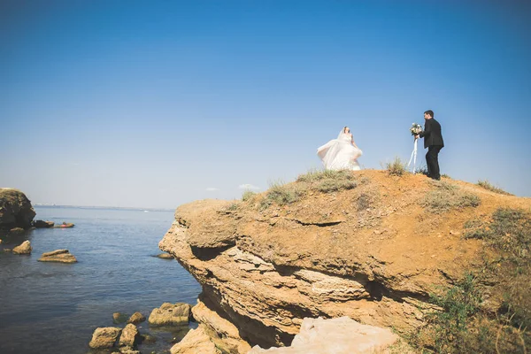 Glückliche und romantische Szene von frisch verheirateten jungen Hochzeitspaaren, die am schönen Strand posieren — Stockfoto