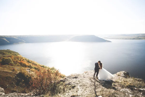 Щаслива і романтична сцена просто одруженої молодої весільної пари позує на красивому пляжі — стокове фото