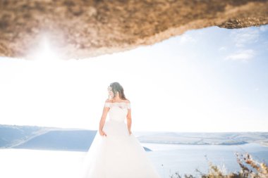 Arka planda beyaz elbiseli romantik gelin pozu